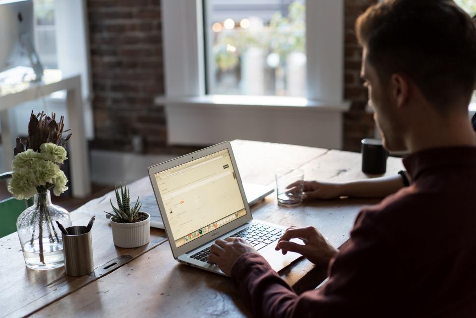 Business owner typing on a laptop while building a website