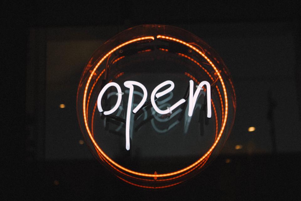 Open sign hanging in a small business shop window